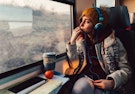A Photo of a Women Sitting on The Train Looking Out The Window